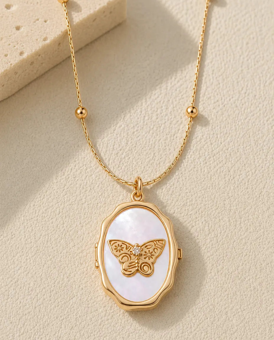 Personalised butterfly mother of pearl photo locket necklace in gold, closed, flat lay