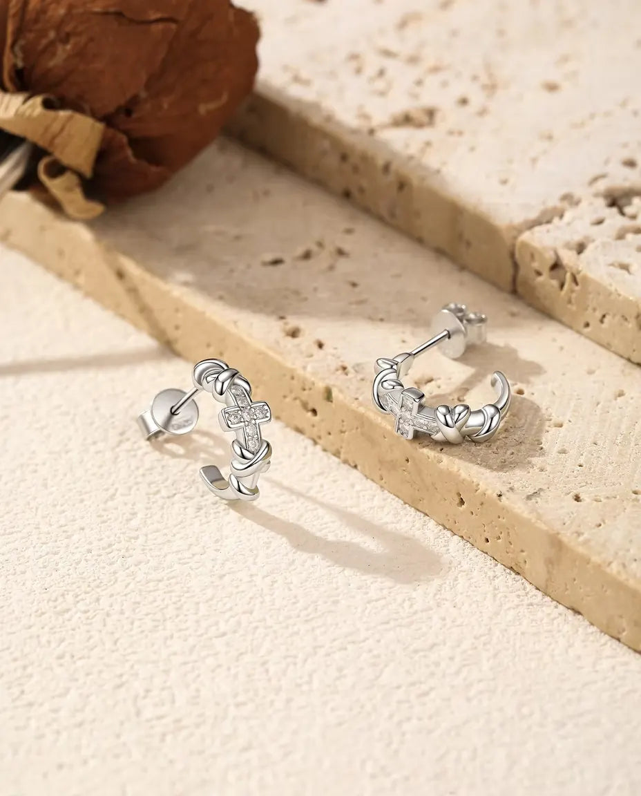 Moissanite Cross Hoop Earrings in 925 Sterling Silver - pair standing side by side on a cream textured surface