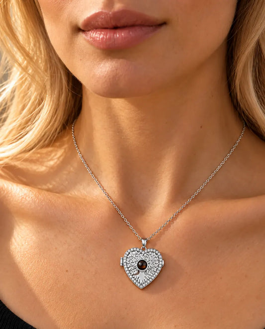 Woman in a black knit top wearing the silver tone tree of life heart projection locket necklace