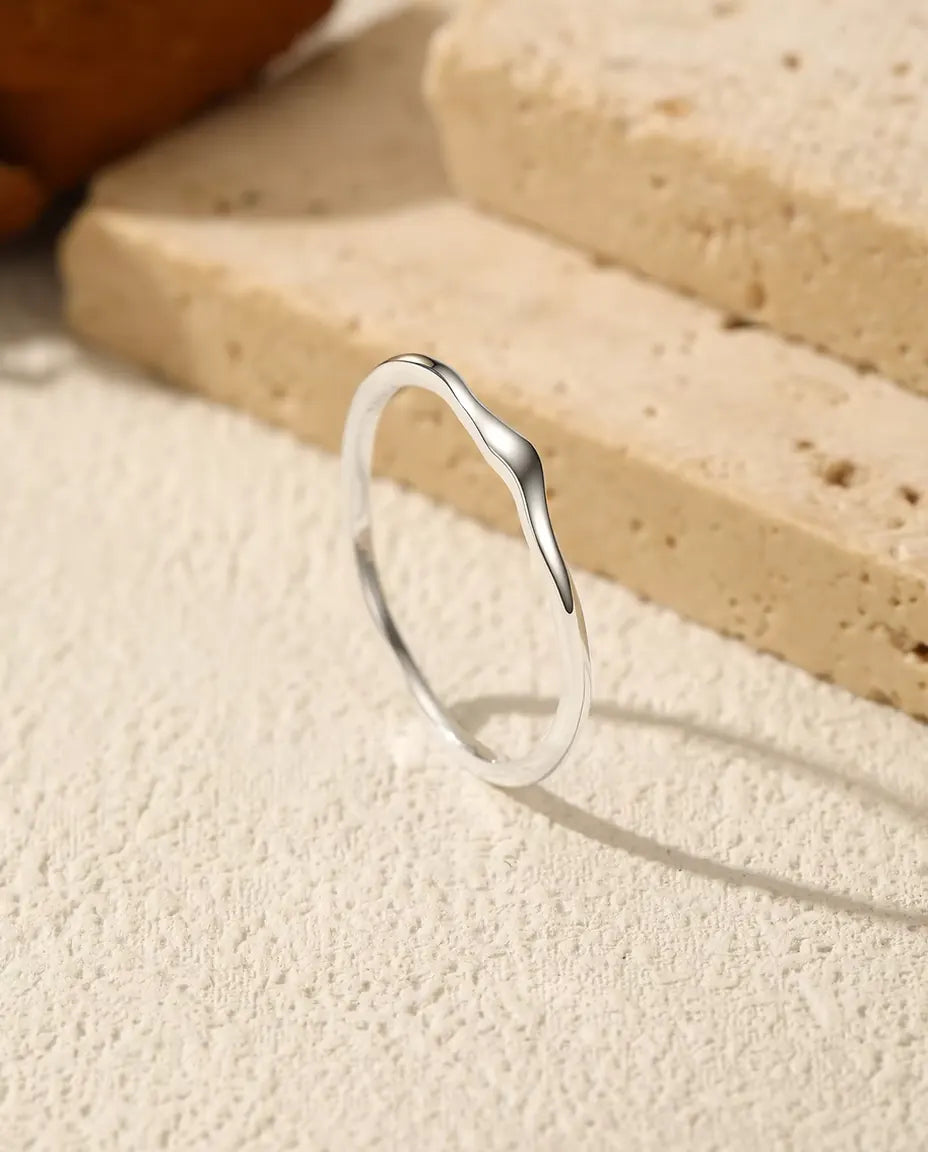 Wavy Stacking Ring in 925 Sterling Silver - standing upright on a cream textured surface