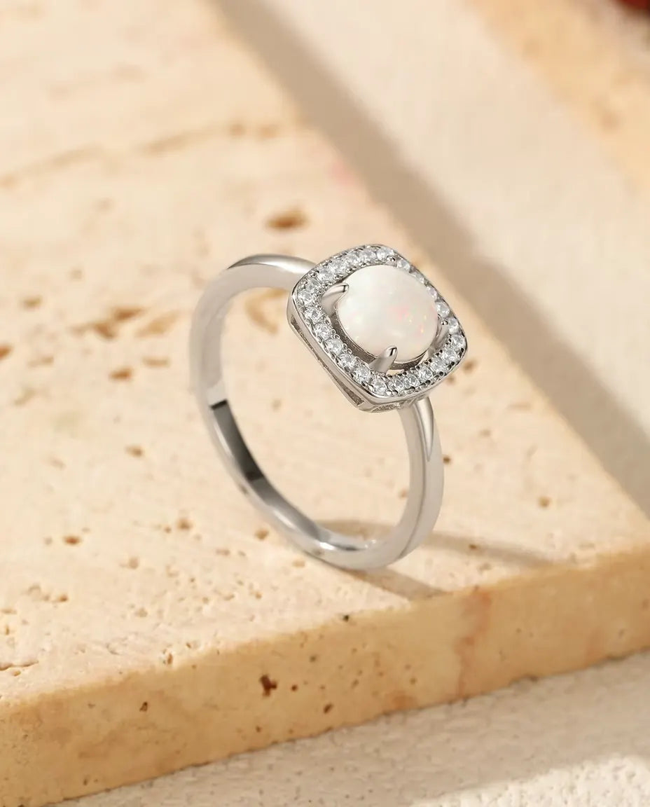 Opal Halo Ring in 925 Sterling Silver - resting on the edge of a travertine slab