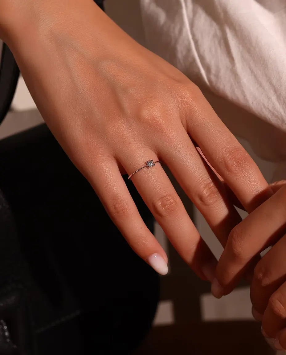 Dainty Moissanite Solitaire Ring in 925 Sterling Silver - worn on a model’s finger, close-up
