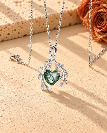 Heart Moss Agate Branch Necklace in 925 Sterling Silver - seen at an angle on a cream textured surface
