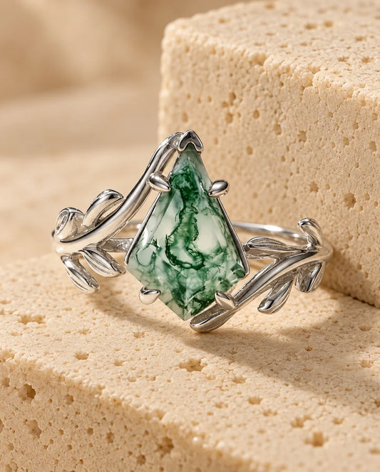 Kite-Cut Moss Agate Ring - displayed on a travertine block