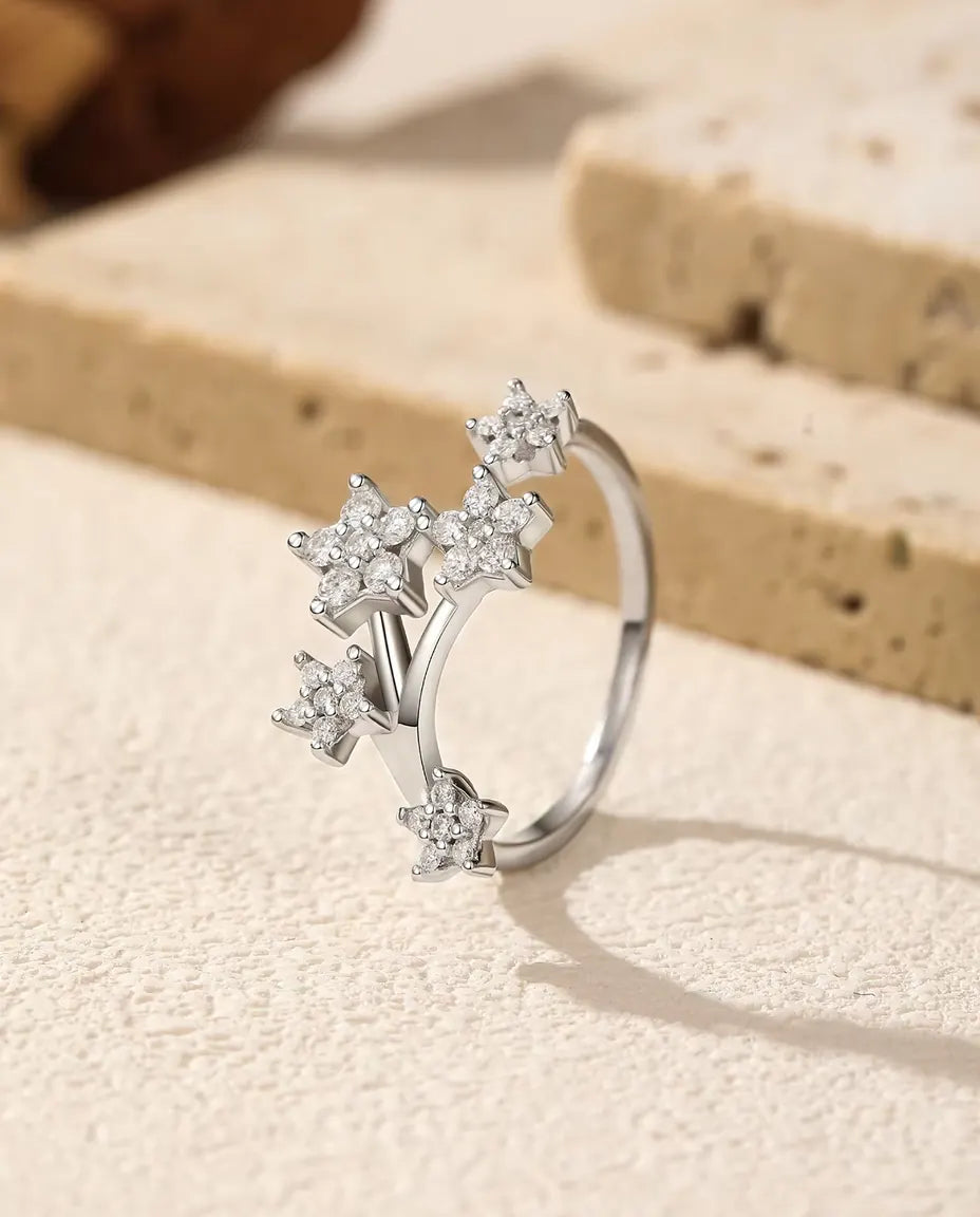 Moissanite Star Cluster Ring in 925 Sterling Silver - standing upright on a cream textured surface