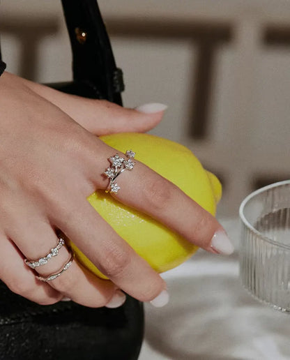 Moissanite Star Cluster Ring in 925 Sterling Silver - worn with other rings, hand holding a lemon