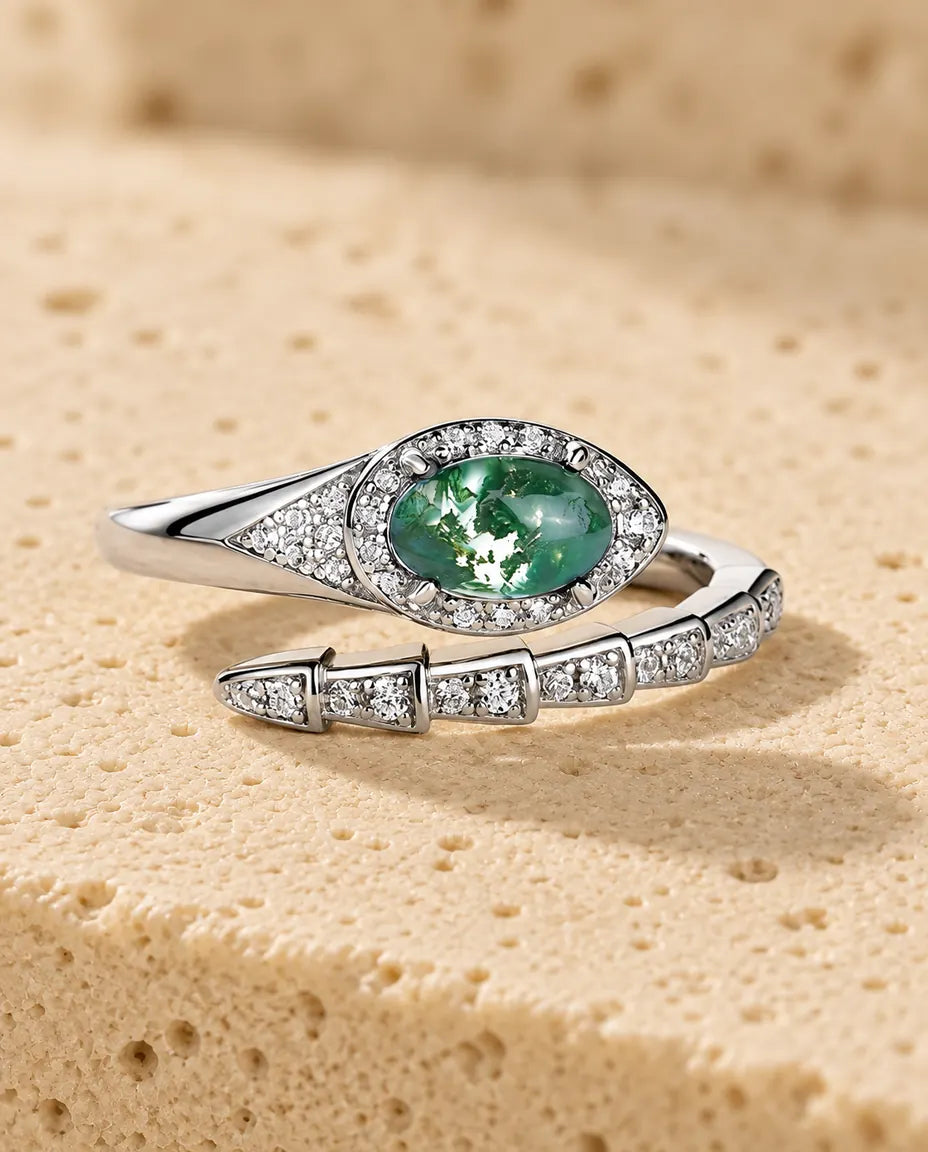Moss Agate Snake Ring in 925 Sterling Silver - lying flat on a cream textured surface
