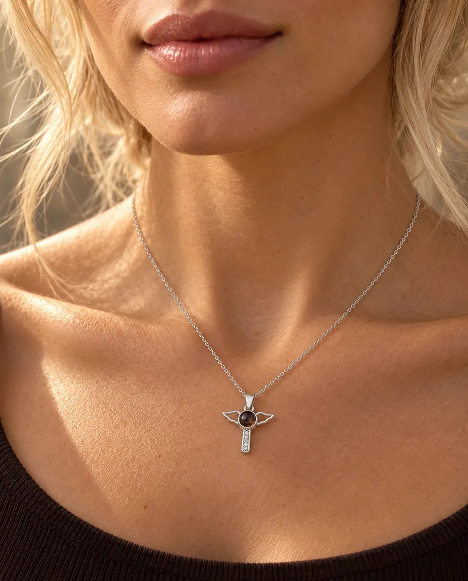 Woman in a brown top wearing the silver tone angel wings cross projection necklace