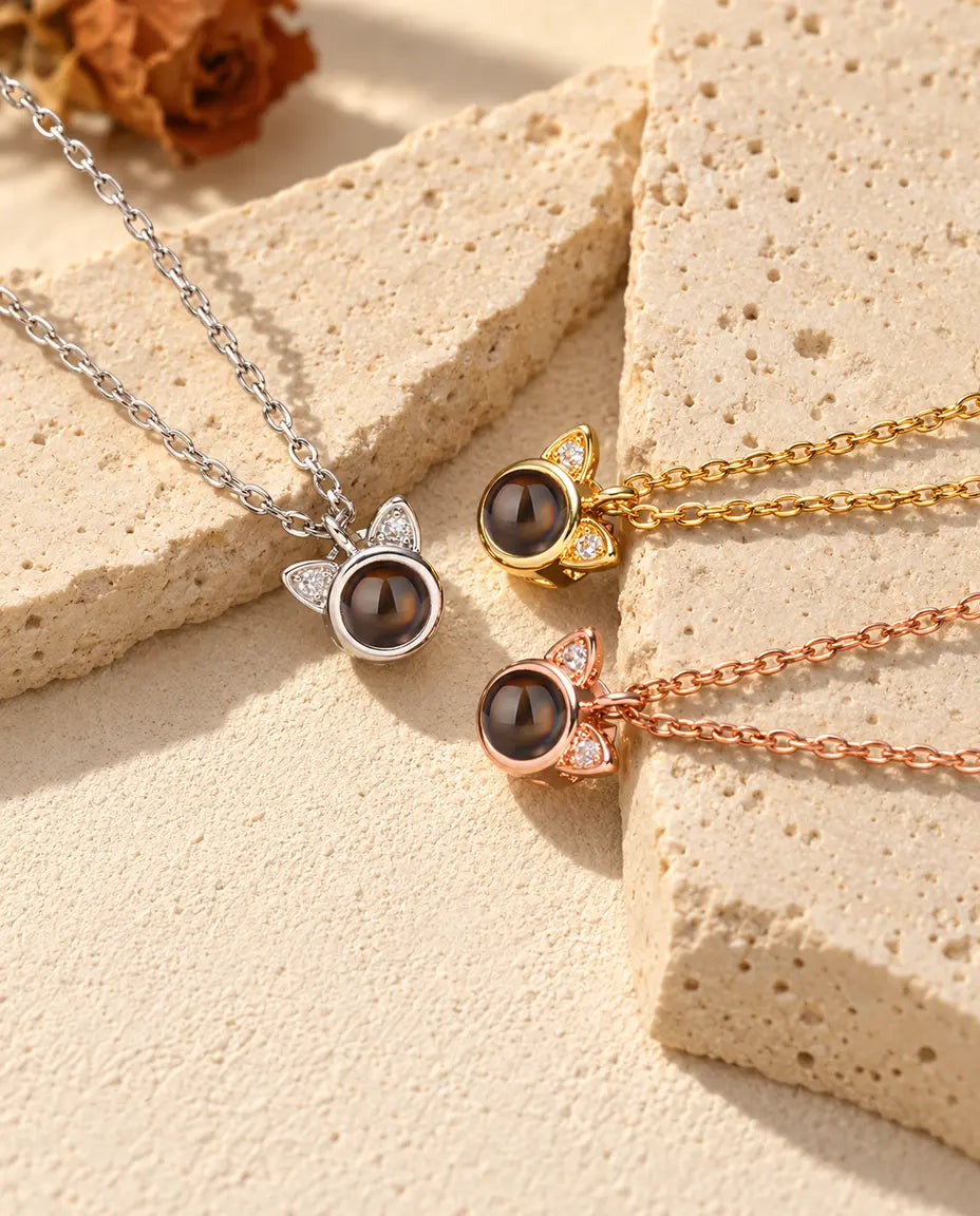 Tiny cat ear projection necklaces in silver tone, gold tone and rose gold tone on travertine