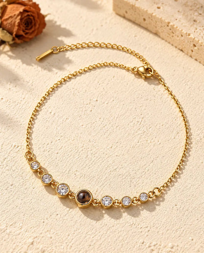 Gold tone stainless steel stone bracelet with a small brown projection stone at the centre