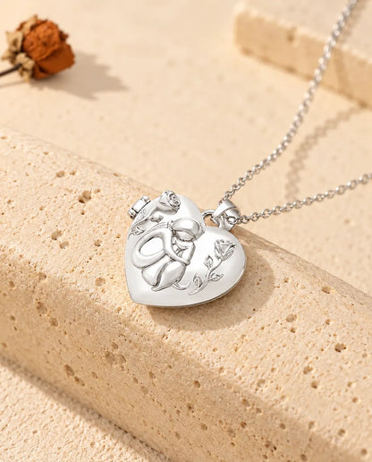 Personalised dog lover heart photo locket necklace in silver tone with a woman hugging her dog and roses, on travertine