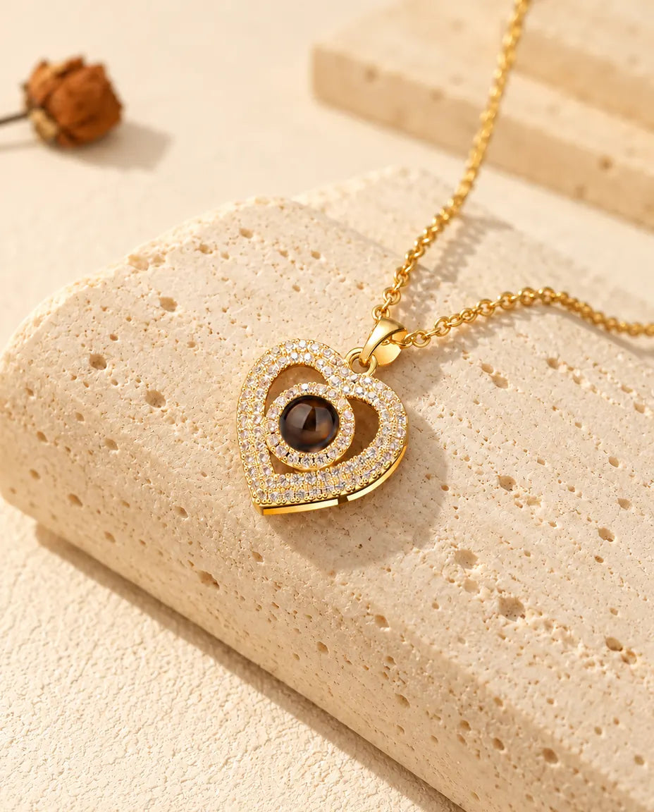 Gold tone double heart necklace with a projection stone at the centre on travertine