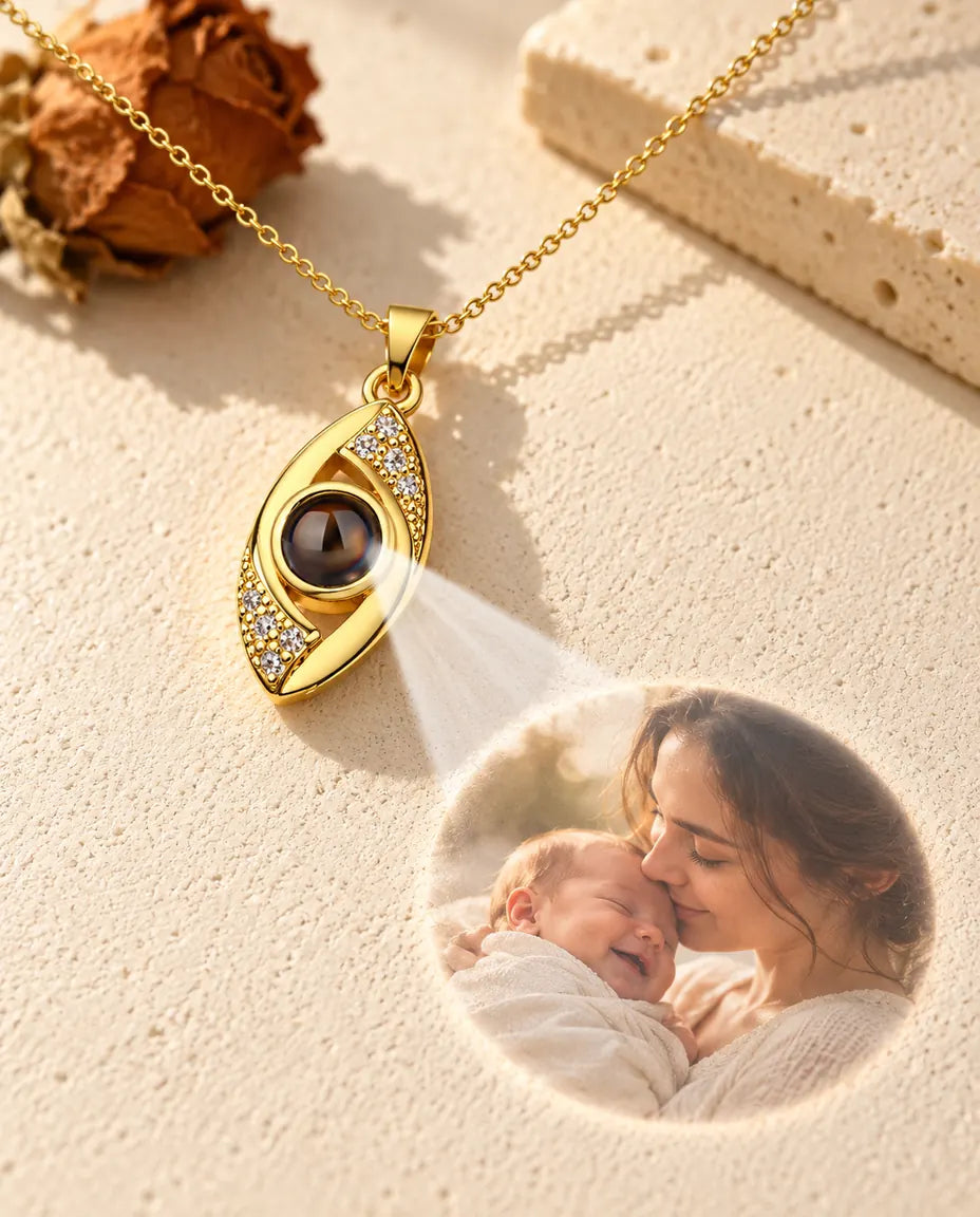 Gold tone evil eye necklace projecting a mother and newborn photo onto plaster