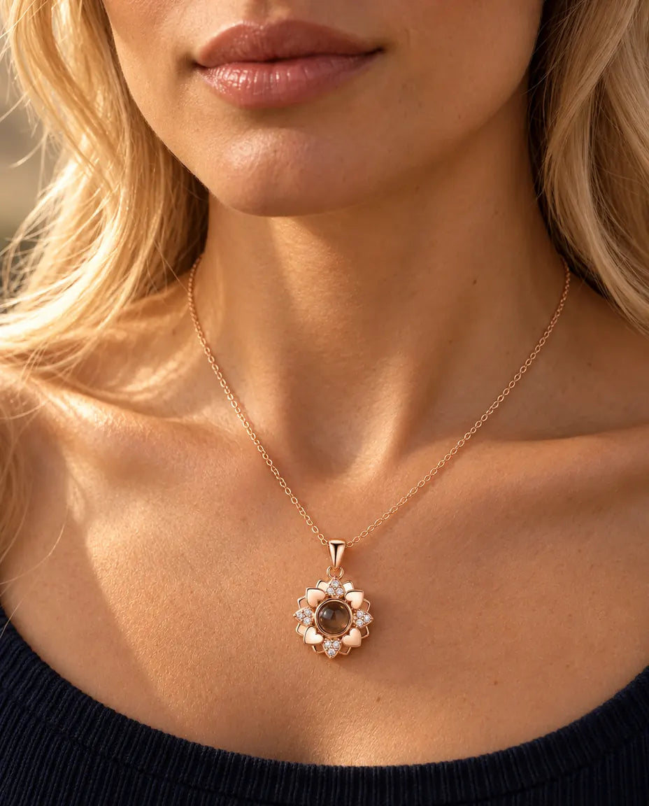 Woman in a navy knit top wearing the rose gold tone heart flower projection necklace