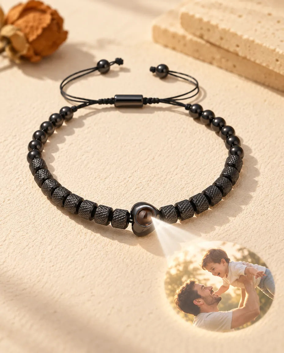 Light through the brown stone of the black heart bead projects a round photo of a father lifting his son