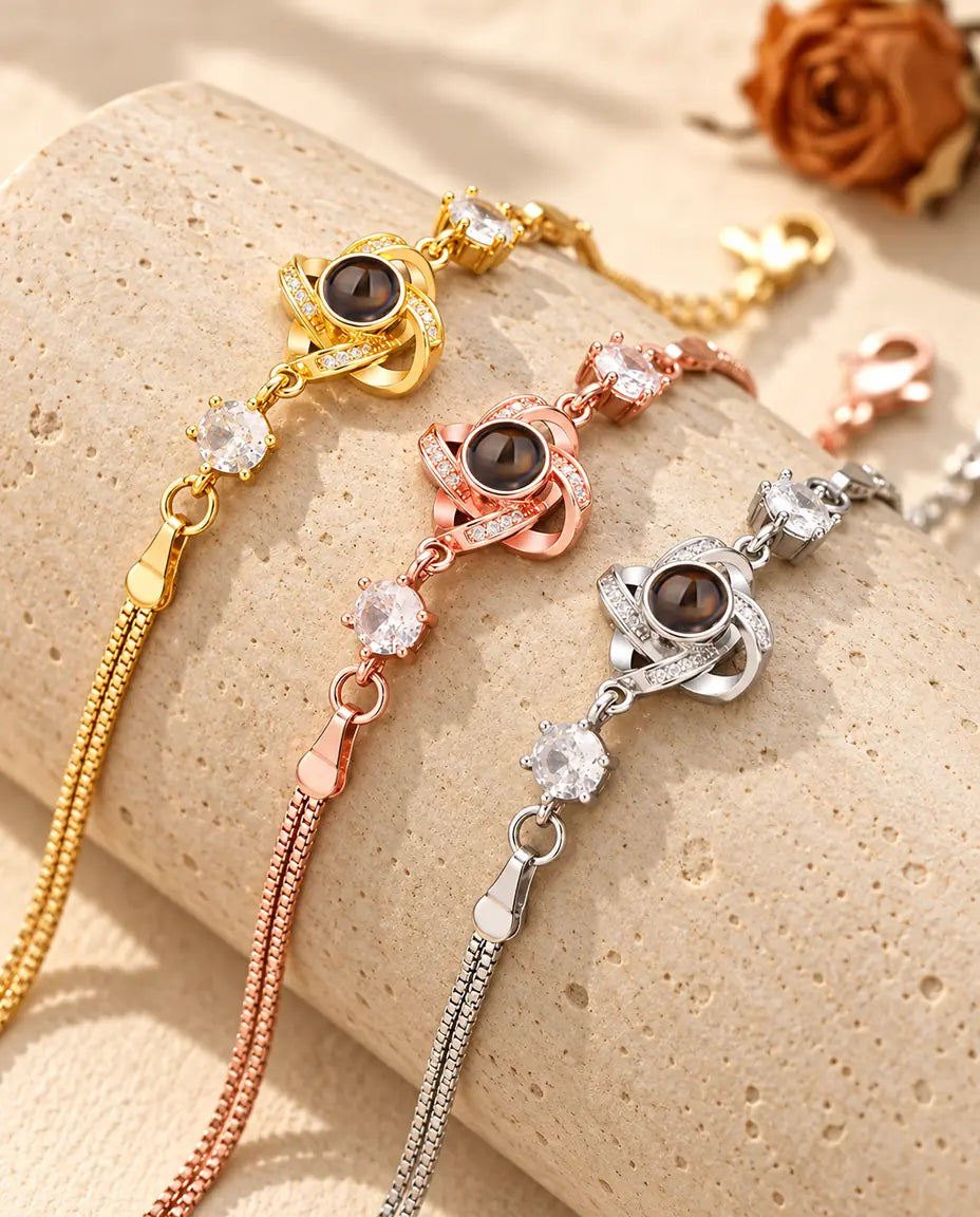 Three love knot projection bracelets in gold tone, rose gold tone and silver tone over a travertine block
