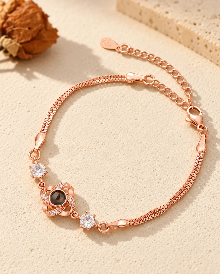Rose gold tone love knot bracelet with sparkling side stones and a double box chain