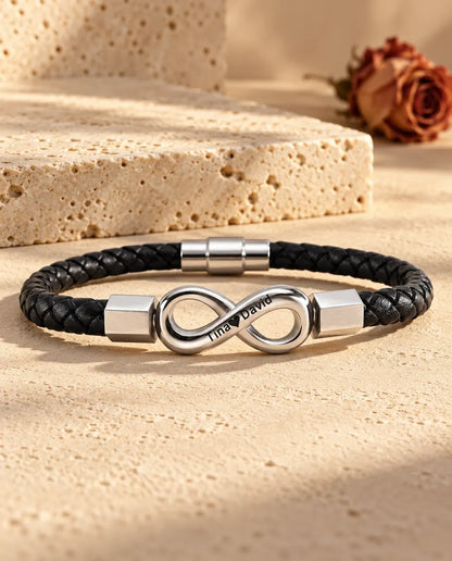Silver stainless steel infinity link with hexagonal end caps on a black braided faux leather bracelet
