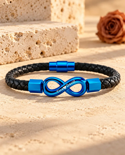 Blue engraved infinity bracelet with blue magnetic clasp on a black braided faux leather cord
