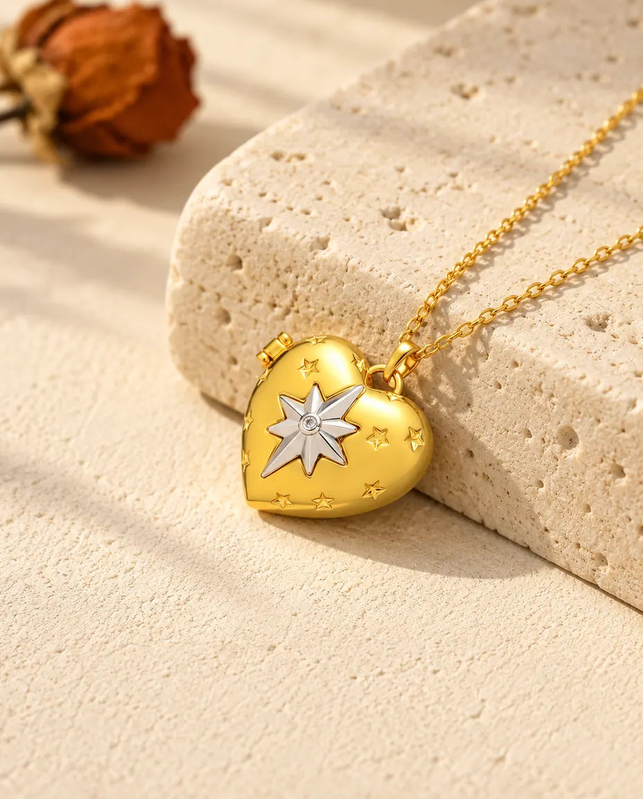 Gold tone north star heart photo locket necklace resting on a travertine block