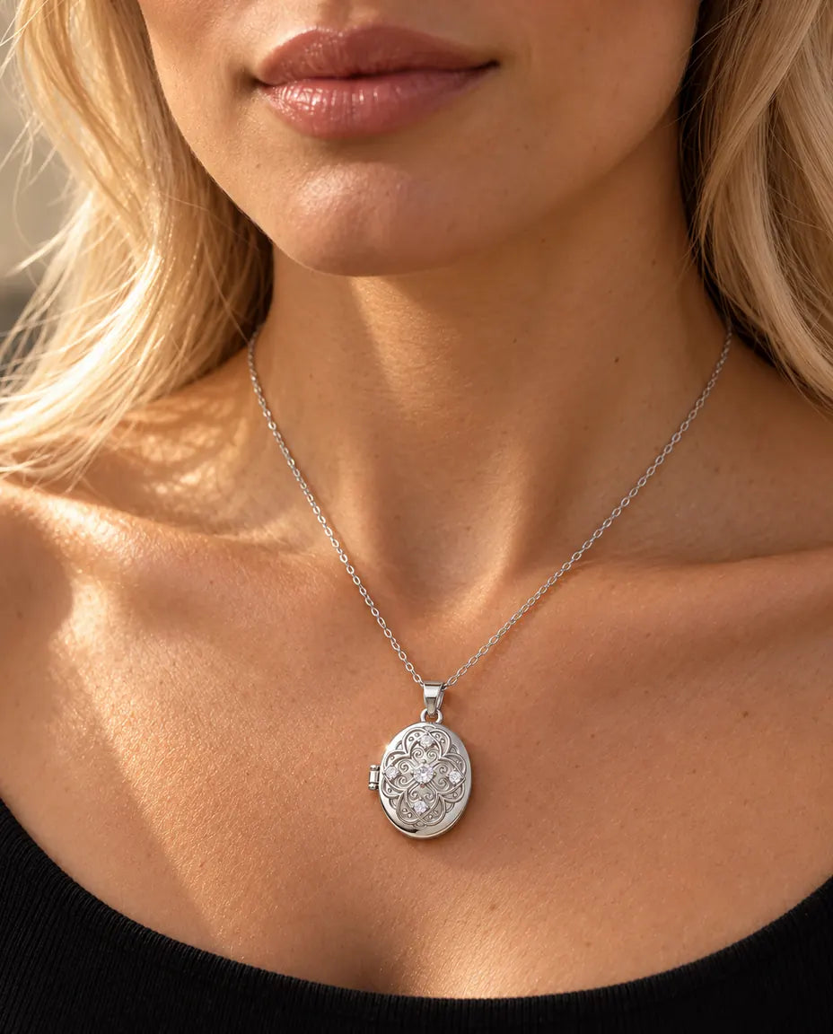 Woman in a black knit top wearing the silver oval filigree photo locket necklace