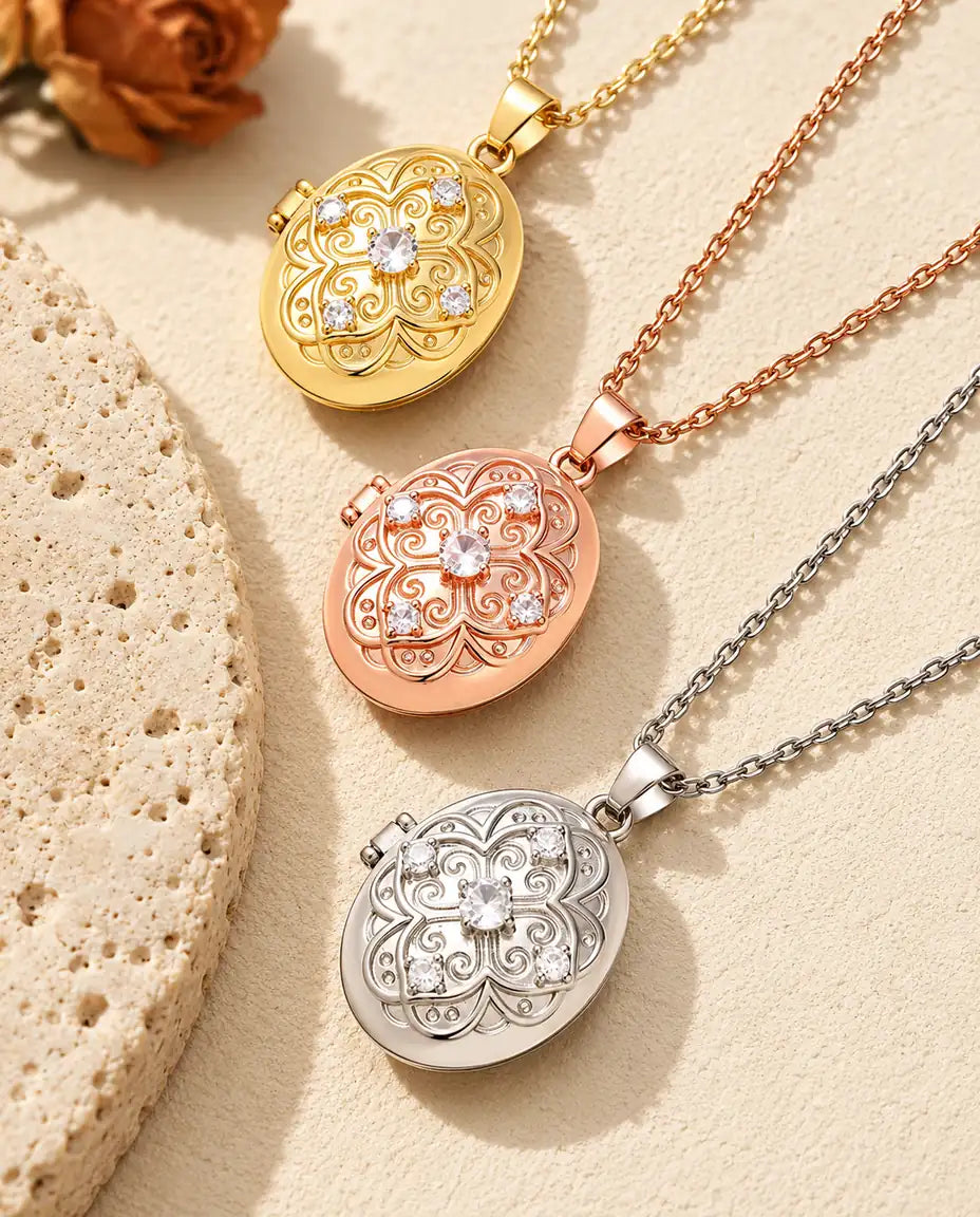 Gold tone, rose gold tone and silver oval lockets stacked beside a travertine slab