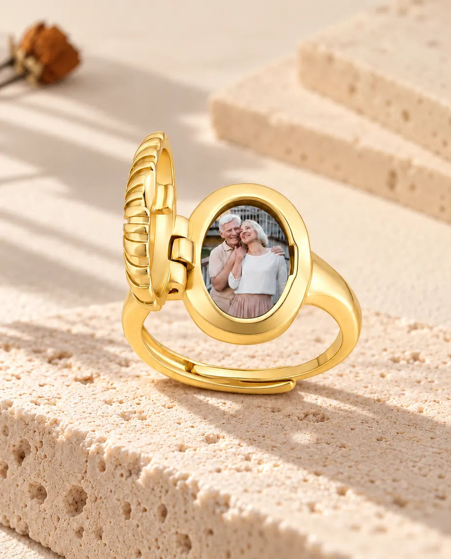 Open oval photo locket ring from the side, showing the hinge and the photo