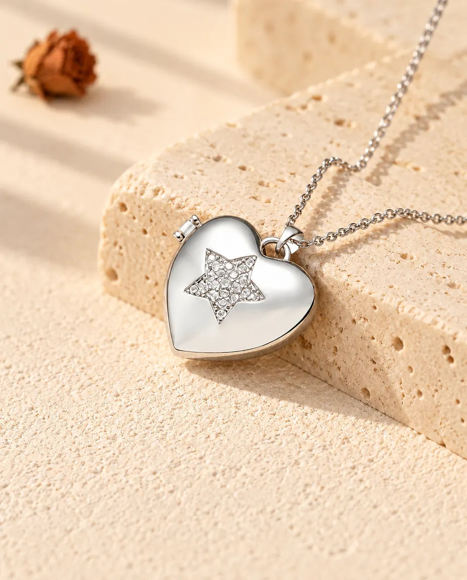 Personalised pave star heart photo locket necklace in silver tone with a cubic zirconia star, resting on a travertine block