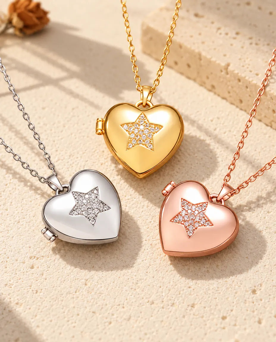 Three colours of the pave star heart photo locket necklace arranged on plaster