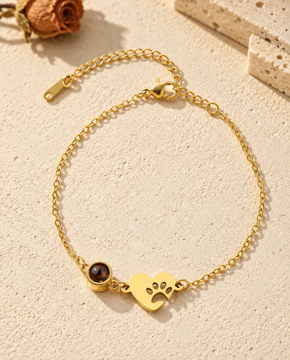Top view of the gold tone paw print heart photo projection bracelet