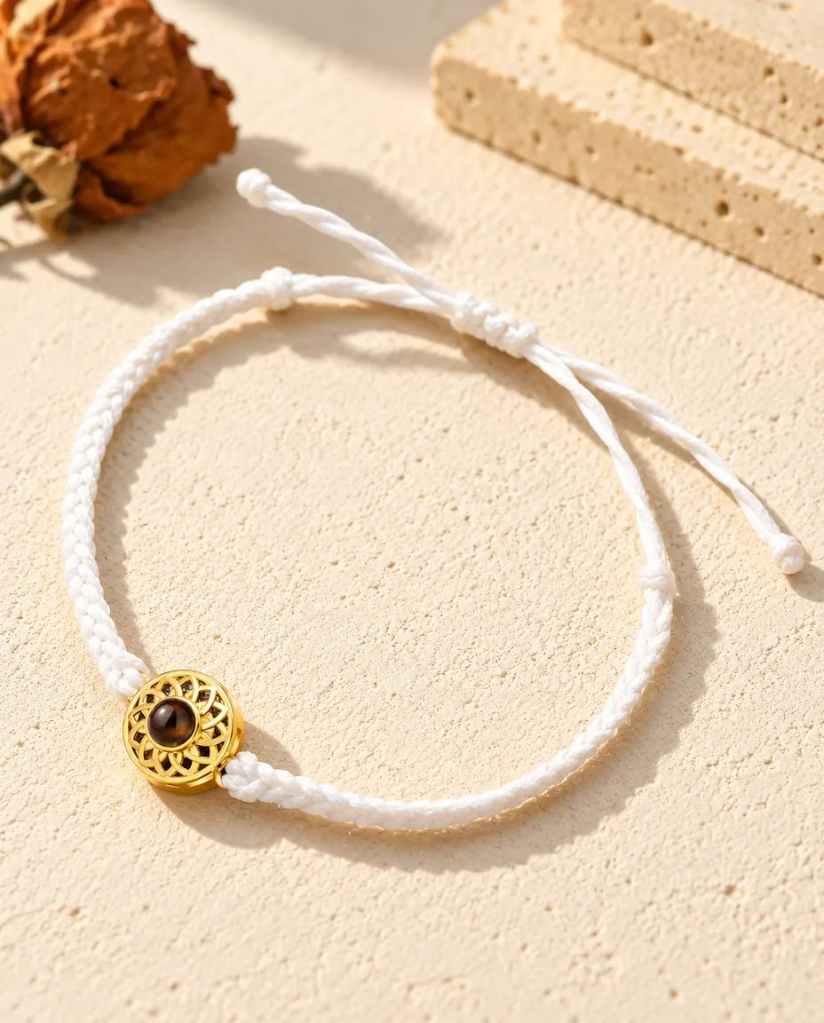 White thin braided cord photo projection bracelet with a gold tone round charm and sliding knot closure