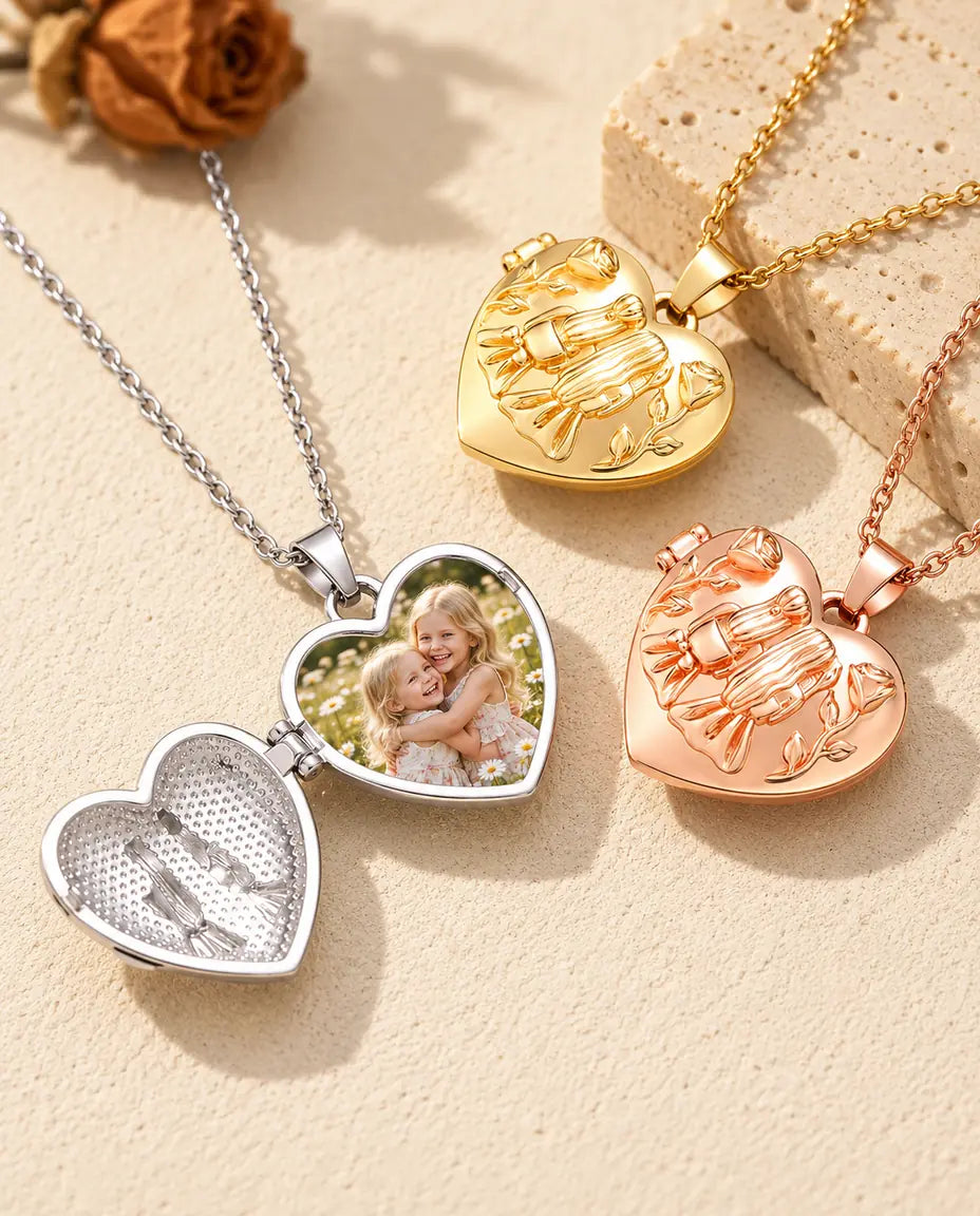 Silver tone sisters heart photo locket opened to show a photo of two little sisters inside, beside closed gold tone and rose gold tone lockets