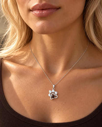 Woman in a brown top wearing the silver paw print pet photo projection necklace