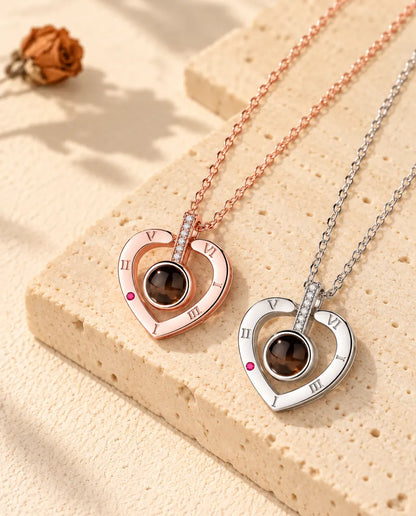 Rose gold tone and silver Roman numeral heart necklaces laid diagonally on plaster