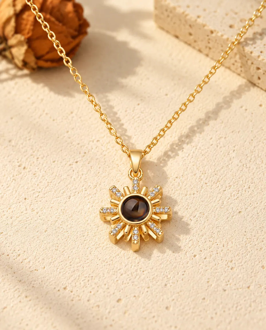 Front view of the gold tone sun pendant with the projection stone at its centre