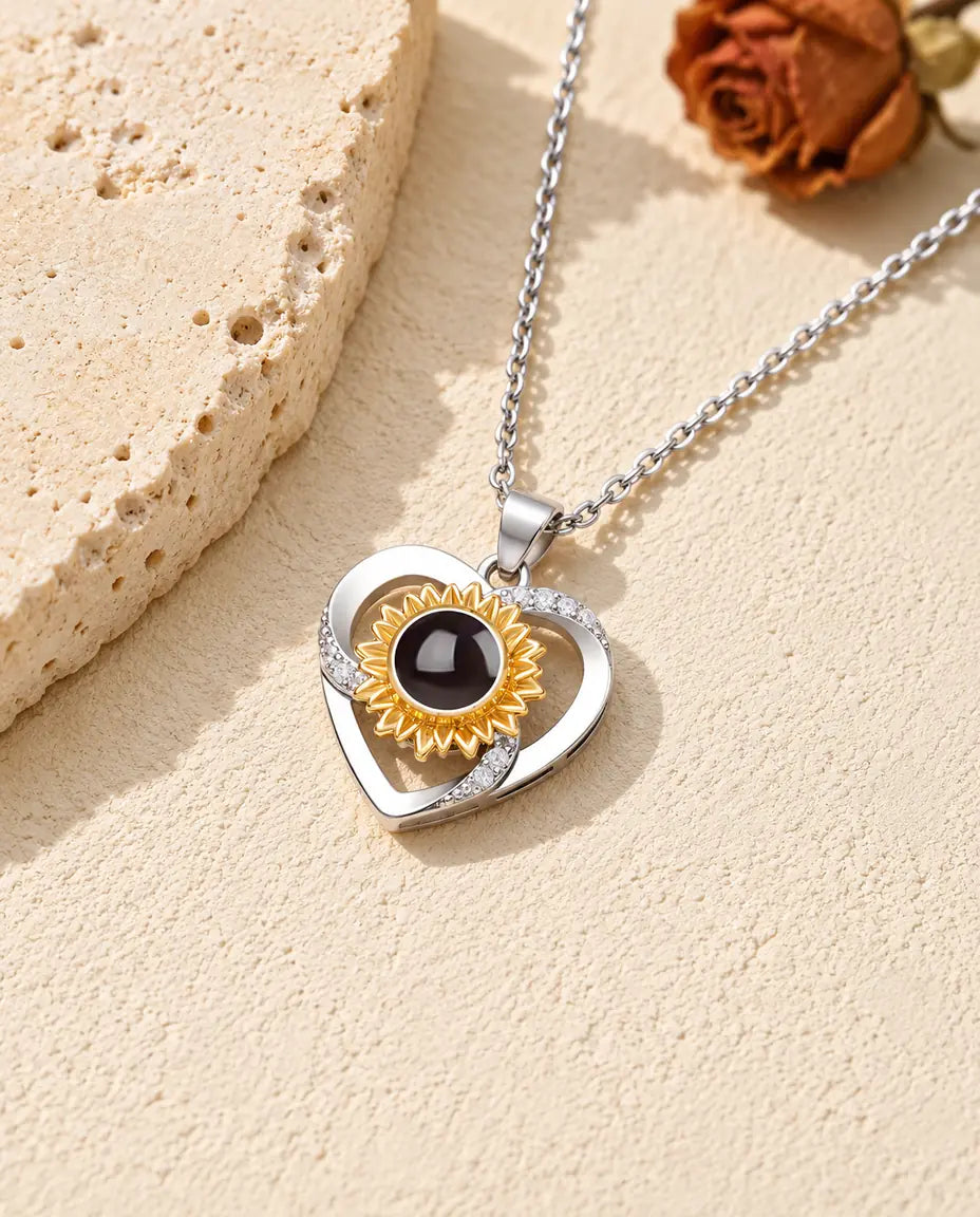 Personalised sunflower heart photo projection necklace with a gold tone sunflower on travertine
