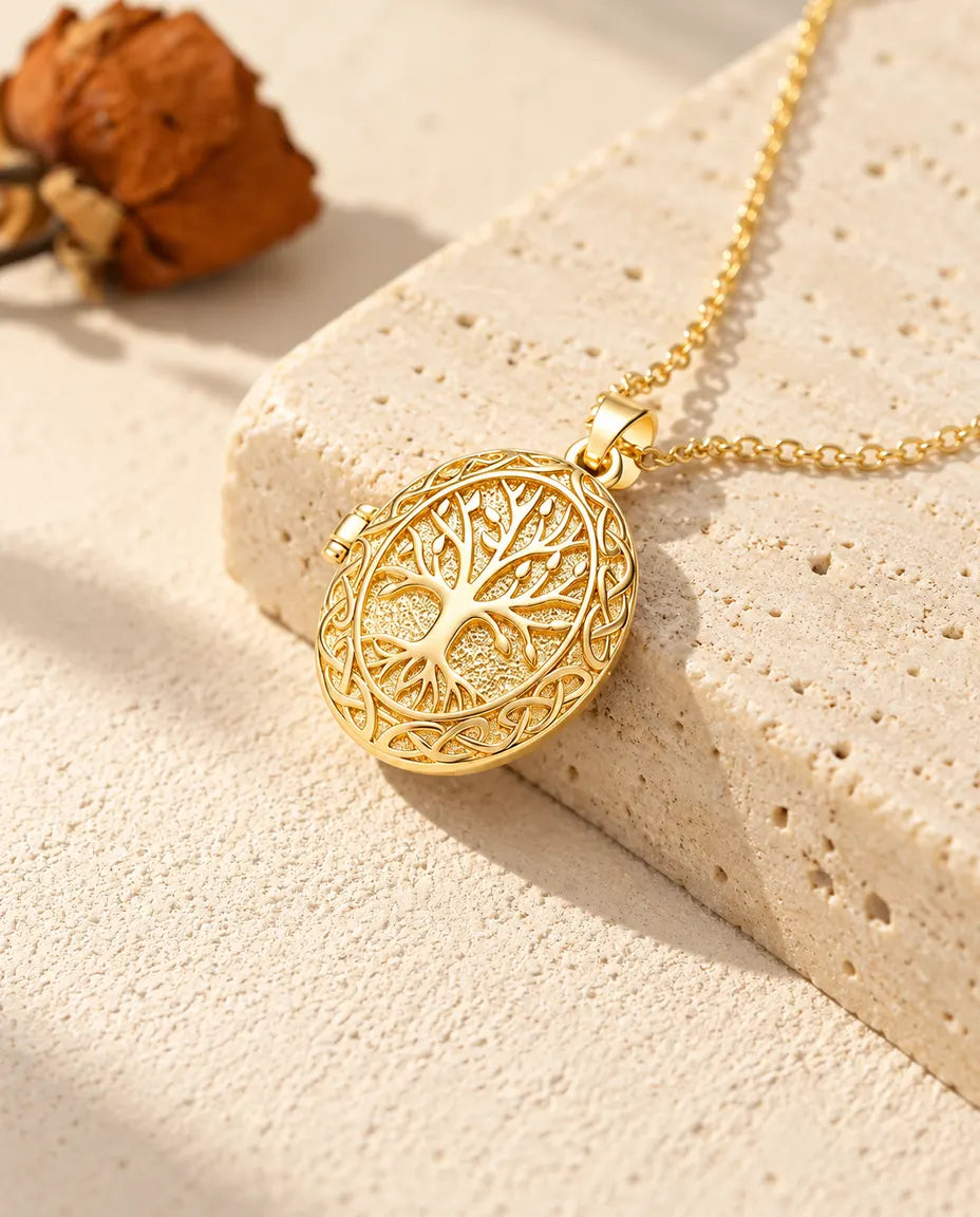 Gold tone oval tree of life locket necklace draped over a travertine block