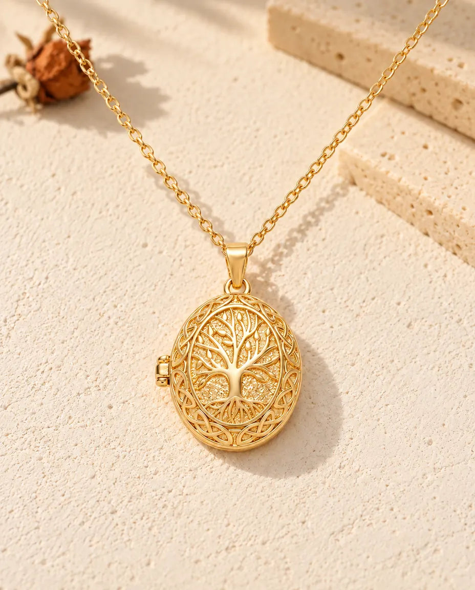 Front view of the gold tone oval locket showing the raised tree of life, knotwork border and side hinge
