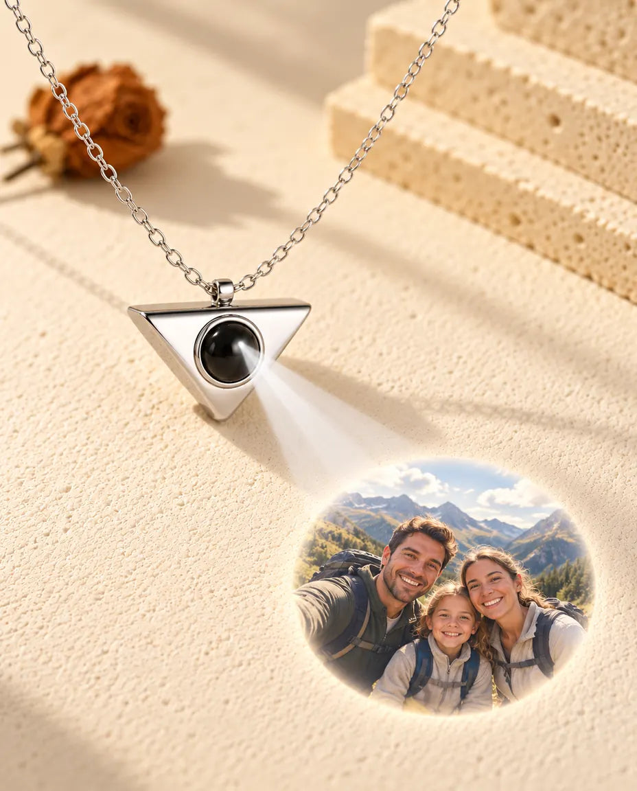 Silver tone triangle necklace projecting a family hiking photo onto cream plaster