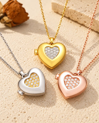 Three colours of the two-tone pave heart photo locket necklace arranged on plaster