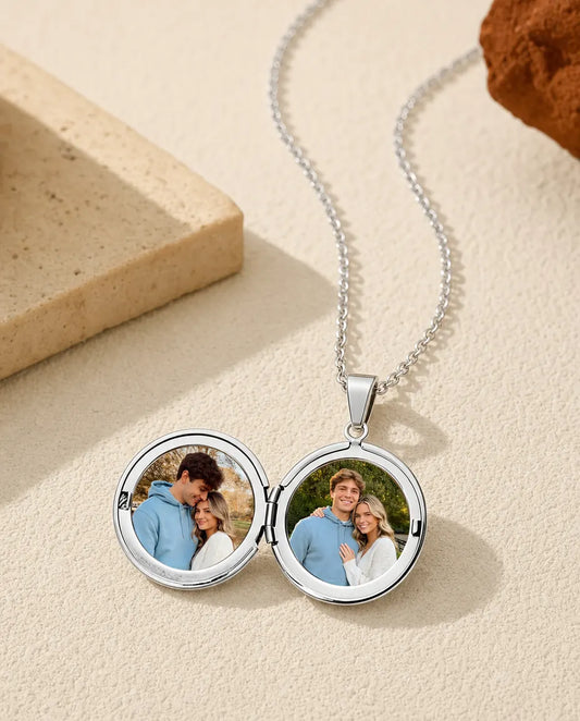 Silver round locket necklace open showing two circular photo frames inside
