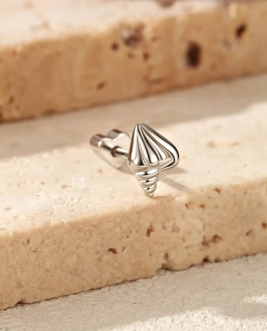 Seashell Stud Earrings in 925 Sterling Silver - standing on the edge of a travertine slab