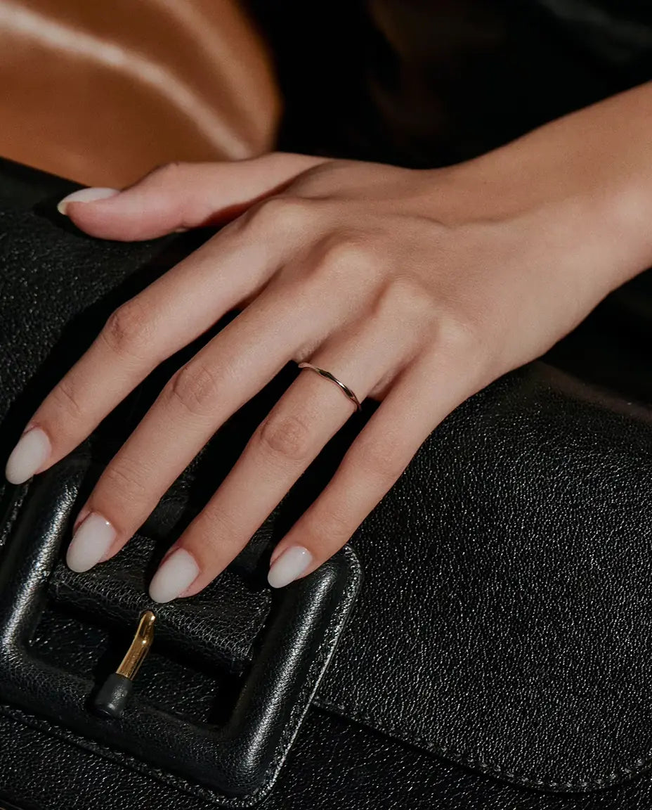 Wavy Band Ring in 925 Sterling Silver - worn on a hand resting on a black bag