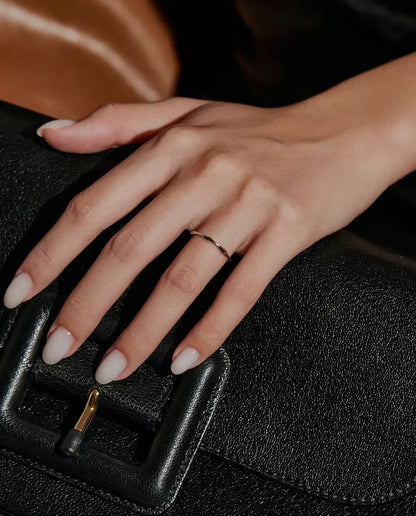 Wavy Band Ring in 925 Sterling Silver - worn on a hand resting on a black bag